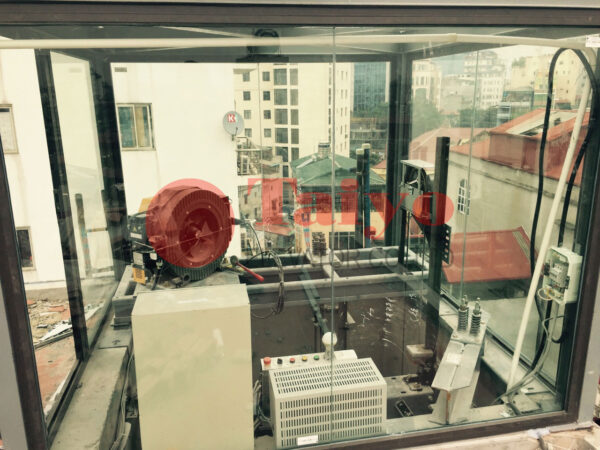 Phòng kỹ thuật thang máy trên mái được bao che bằng khung nhôm kính.